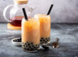 Image of two boba milk tea drinks in a glass