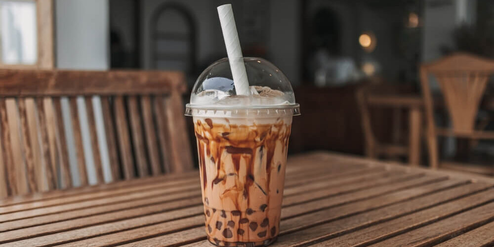 Image of an iced boba drink on a table inside a boba shop