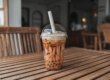 Image of an iced boba drink on a table inside a boba shop