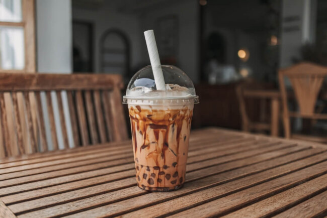 Image of an iced boba drink on a table inside a boba shop