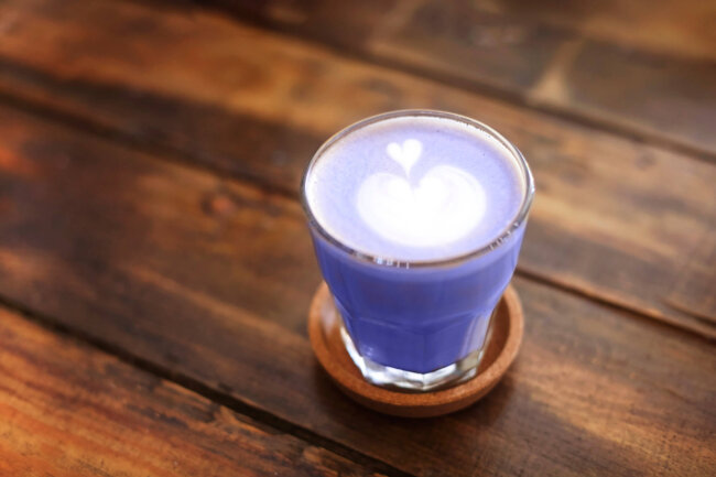 Glass mug with latte on wooden table